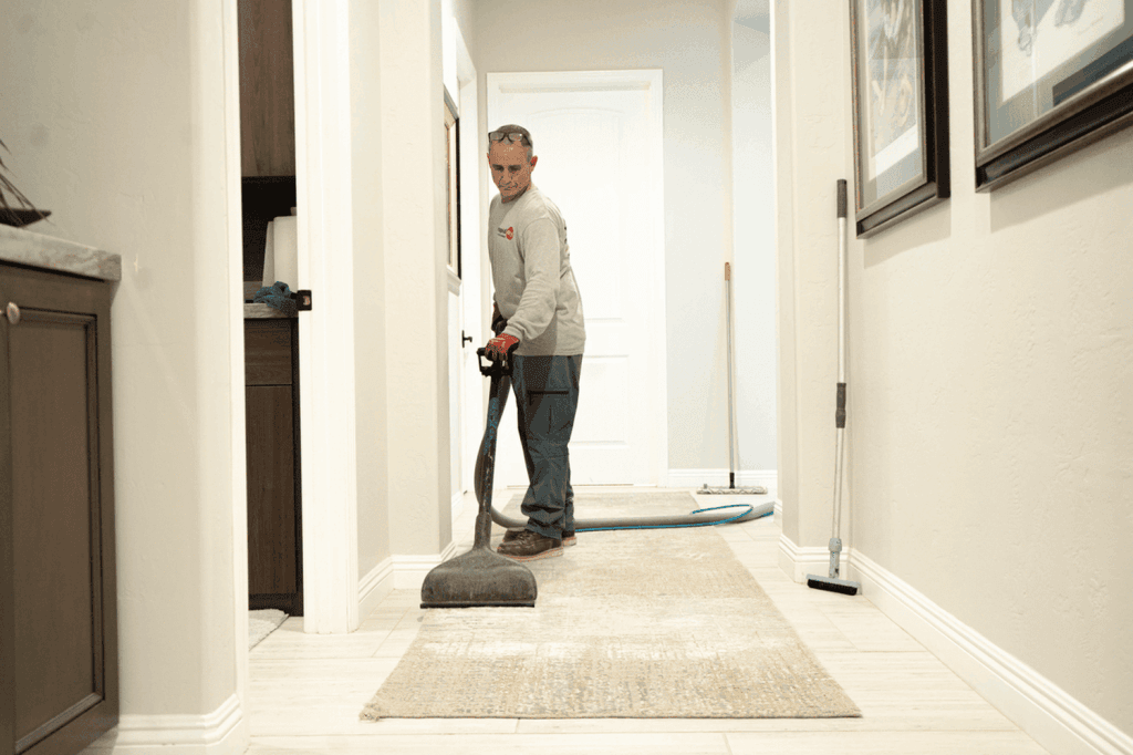 Professional cleaner using a carpet cleaning machine in a residential hallway, showcasing VM Demolition's cleaning services for a spotless environment.